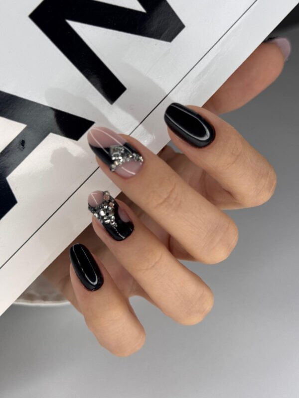 Manichiură neagră lucioasă cu accent nail decorat cu cristale, formă migdală